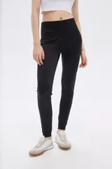 Calza negra de poliamida, corte skinny y tiro alto.