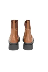 Bota Chelsea color marrón, de cuero liso, con elásticos laterales al tono y suela chunky de goma negra antideslizante.