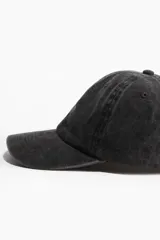 Gorra de sarga de algodón color gris oscuro con diseño liso y ojales bordados en la parte superior. Trabilla ajustable con hebilla de metal atrás y cinta antitranspirante de algodón.