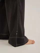 Pantalón negro de tiro medio alto, corte palazzo, con bolsillos delanteros y traseros.
