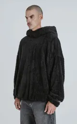 Hoodie negro oversize con cierre central al estilo anorak, confeccionado en piel de corderito sintético. Capucha ajustable con cordón y bolsillo canguro.