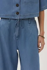 Pantalón de jean celeste de corte ancho, con cintura alta y lazo ajustable.