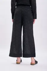 Pantalón negro con bordado calado, de corte palazzo y tiro alto.