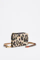 Monedero Bimba y Lola con estampado animal print, confeccionado en nylon con detalles en piel. Cuenta con cierre de cremallera, tirador de piel y cordón, logo metálico y tarjetero interior.