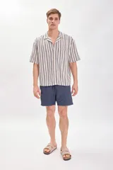 Short de baño azul marino con bolsillos laterales y cintura elastizada con cordón ajustable.