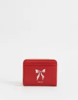 Billetera de cuerina color blanco con estampado de corazones rosas y lazos azules, cierre perimetral con cremallera y múltiples ranuras para tarjetas.