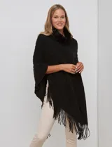Poncho tejido negro con textura, cuello alto de velour negro y terminación con flecos largos en el ruedo.