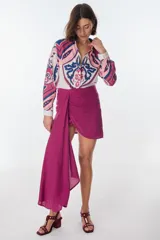 Conjunto de camisa celeste de mangas largas abullonadas y falda turquesa con detalle fruncido y lazo en el lateral.