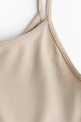 Top corto color beige de punto elástico, con breteles finos y escote redondo.