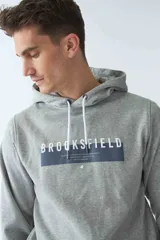 Buzo canguro de felpa color bordó, con capucha ajustable con cordones blancos, fit regular, manga larga, bolsillo canguro y logo estampado en el pecho.