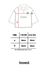 Chomba negra de corte cuadrado con cuello polo y mangas cortas. Presenta un escudo estampado en el pecho con diseño de fútbol retro y la palabra 'boxed' estampada en el frente.