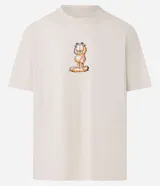 Remera color crema de corte relajado, cuello redondo y manga corta. Estampado frontal con el personaje de Garfield.