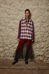 Camisa holgada con estampado de rombos en tonos rosa y marrón, con cuello solapa y abotonada. Tiene mangas largas con rayas verticales en tonos borgoña y violeta.