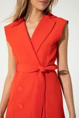 Vestido corto color coral, estilo blazer sin mangas, con cuello en V cruzado, doble botonadura y cinturón al tono.