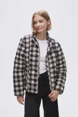 Campera puffer estampada a cuadros en blanco y negro con pequeños corazones rosados, cierre frontal con cremallera y bolsillos laterales.