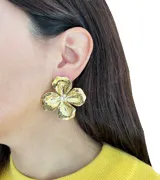 Par de aros dorados con forma de flor de cuatro pétalos y detalle de perlas en el centro.