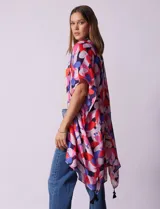 Kimono tejido con estampado floral multicolor y terminación de ruedo con borlas negras.