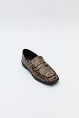 Mocasines negros de símil cuero texturizado, con punta cuadrada, detalle de bordado a tono en la capellada y taco de 2,5cm.