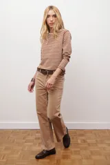 Remera de manga larga con diseño de rayas horizontales en azul y blanco, destacada por un cuello redondo en color bordó con costuras a la vista.