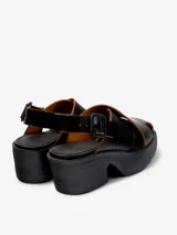 Sandalias negras de cuero vacuno con plataforma y tiras cruzadas.