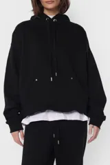 Buzo hoodie de frisa color beige, de silueta oversize, con puños y cintura de rib al tono, capucha forrada en su interior, bolsillo canguro, cordones con ojalillos y punteras metálicas personalizadas con marca, tanca para regular cordones, remaches en boca de bolsillo y bordado en espalda a contratono.