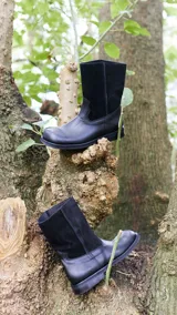 Botas de cuero vacuno color negro, con caña media y suela de caucho.