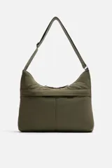 Bolso de hombro color verde oliva, fabricado en tejido técnico acolchado. Tiene un compartimento principal con cierre de cremallera, un bolsillo interior con cremallera y un bolsillo frontal con cremallera. El asa de hombro es ajustable.