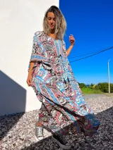 Túnica larga de mangas anchas con estampado de arabescos en tonos celeste, rosa, negro y beige.