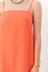 Vestido corto de lino color azul con breteles finos y corte recto.