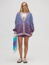 Cardigan tejido de punto con patrón de rombos en degradé de grises y blanco. Tiene corte oversize, mangas largas y cierre frontal con botones.