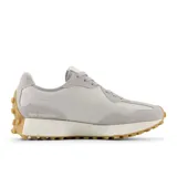 Championes New Balance modelo 327 para mujer, con capellada en tonos blanco roto y gris claro, y el logo 'N' lateral en color rosa. Suela de goma color caramelo con relieve pronunciado.