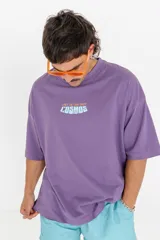 Remera violeta de corte holgado con estampa frontal con la frase "Lost in the vast cosmos".