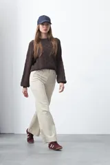 Pantalón negro de tiro alto, corte recto y silueta clásica. Presenta costuras verticales marcadas en la parte delantera de las piernas.