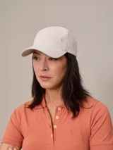Gorro con visera color beige confeccionado en lino, con logo bordado en el lateral.