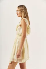 Vestido corto color crema con textura brillante, escote redondo con volados y cintura elastizada.