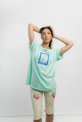 Pantalón capri color crema con estampado de caras y flores, tiro medio y corte ajustado.
