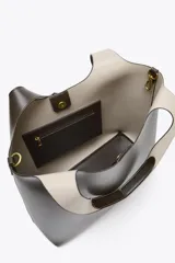 Bolso shopper de hombro color marrón oscuro, con doble tira ancha, bolsillo interior con cierre mediante cremallera metálica y cierre imantado.