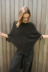 Poncho tejido en hilo de algodón con lurex color negro y dorado, con flecos en el ruedo.