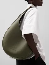 Bolso hobo grande color marrón con textura granulada. Tiene un compartimento con cierre magnético, un bolsillo interior y asa corta regulable.
