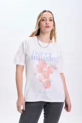 Remera blanca de algodón con cuello redondo y mangas cortas. Estampado frontal con la frase "Berry Infusion" en color lila y dibujo de frambuesas en color coral.