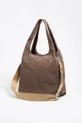 Bolso de mano grande color beige, confeccionado en nylon y con parte inferior de red. Tiene doble asa de mano, asa de tejido regulable, bolsillo interior, cierre de tejido, etiqueta de piel logotipada y acabados metálicos plateados.