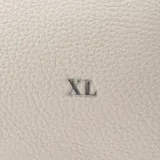Cartera tipo tote color hueso, confeccionada en símil cuero graneado. Tiene doble asa corta fija y correa larga regulable extraíble. El acceso es con cierre. Cuenta con un compartimento principal, un bolsillo interno con cierre y un bolsillo interno abierto. Los herrajes son plateados y el interior es de tela de algodón y poliéster.