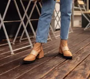 Botas cortas color beige con elástico ancho color crema, suela de goma negra y taco de madera.