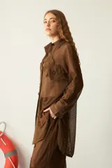 Camisola blanca traslúcida de red con bordado de flores, de corte recto y mangas largas.