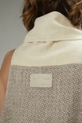 Chaleco largo sin mangas con cuello volcado y diseño geométrico en tonos beige, marrón y gris. Tejido en lana con terminaciones en crochet.