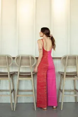 Mono de tejido de punto color negro con brillo sutil, de corte ancho en las piernas y escote redondo en la espalda.