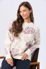 Buzo tejido en jacquard color crema con estampado de rosas azules y hojas marrones. Tiene cuello redondo y puños de rib.