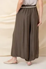 Pantalón palazzo blanco de viscosa, con cintura elastizada, cinto trenzado y bolsillos laterales.