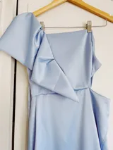 Vestido largo color salmón de un solo hombro, con manga corta abullonada y falda con abertura lateral y volados.