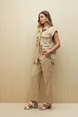 Pantalón beige de tiro medio con cintura elastizada y cordón regulable, bolsillos laterales y calce relajado.